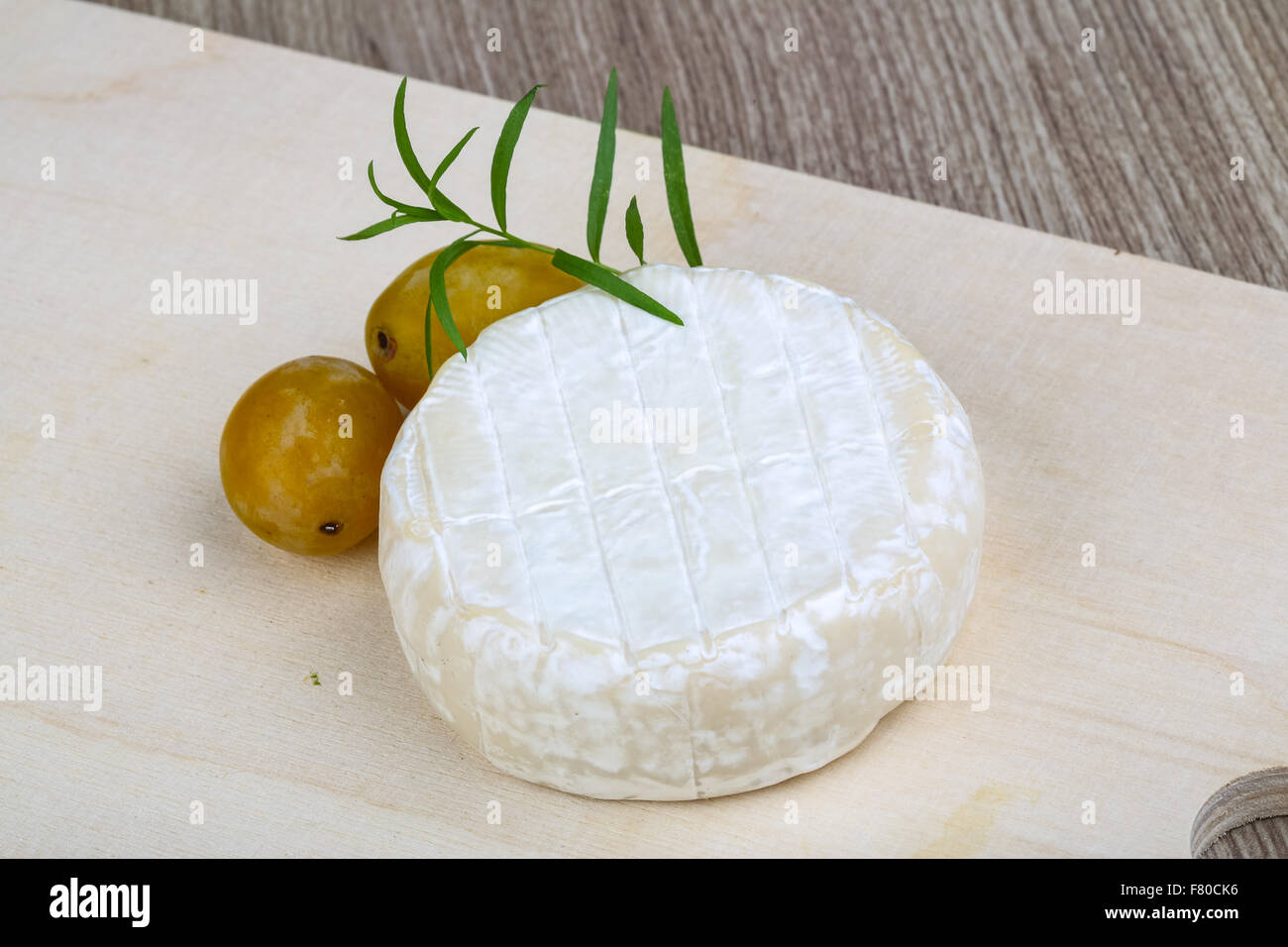 Round Brie cheese with yellow plums and estragon Stock Photo Alamy