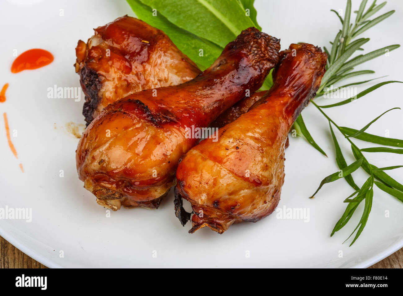 Roasted chicken legs with rosemary on the wood background Stock Photo