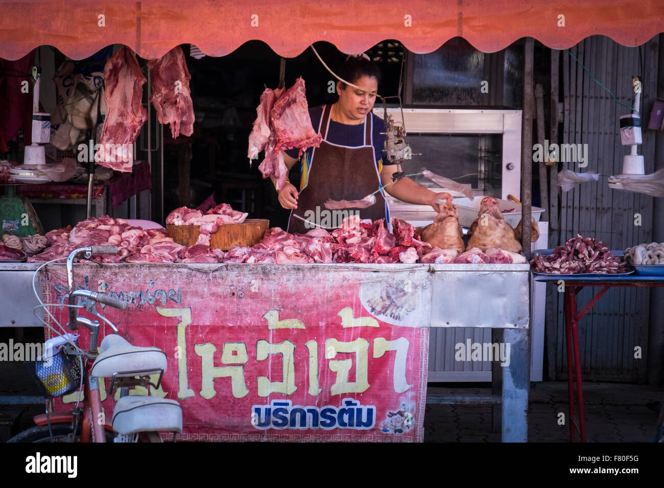 A woman selling meat from her street stall in Chiang Khong, Northern Thailand Stock Photo