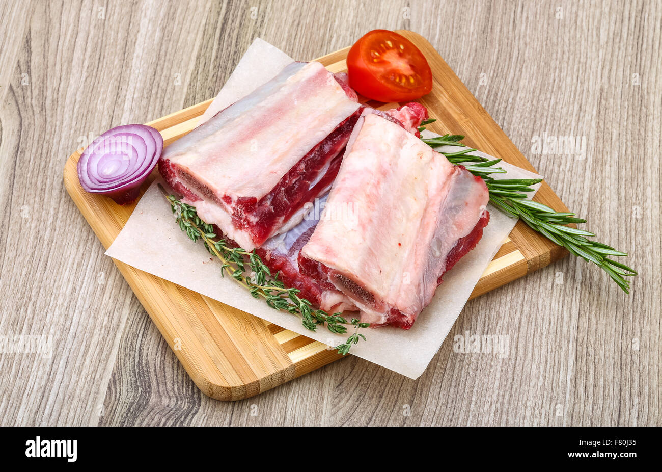 Raw beef ribs with rosemary and thyme ready for cooking Stock Photo
