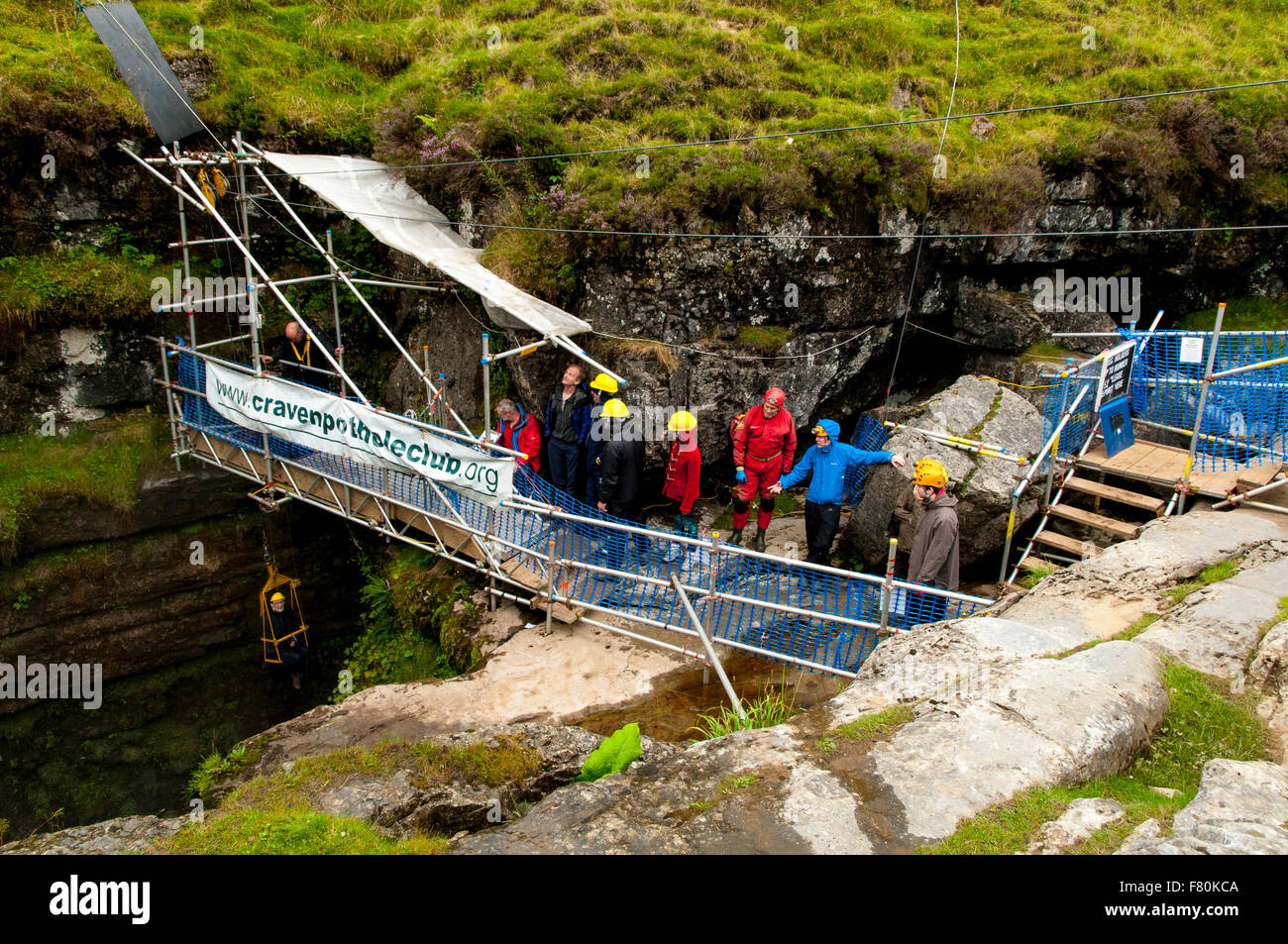 A visitor in a bosun's chair being winched down into the chamber of Gaping Gill by members of the Craven Pothole Club. Yorkshire Stock Photo