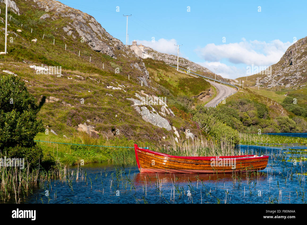 A small boat afloat on the waters of Loch Dubh at Tarbet, Sutherland, Scotland. August. Stock Photo