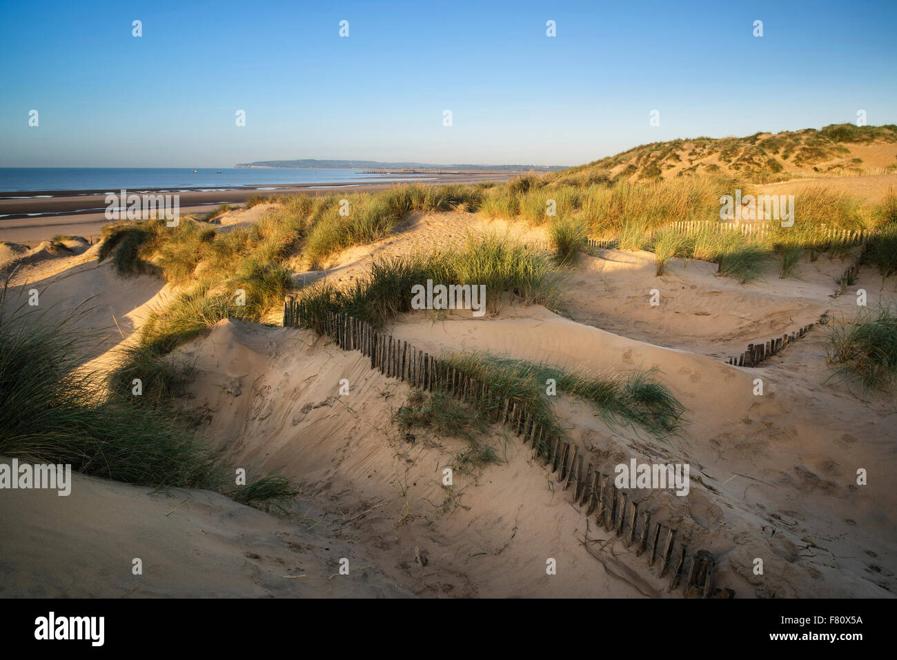 Stunning sunrise over sand dunes system on yellow sand golden beach Stock Photo