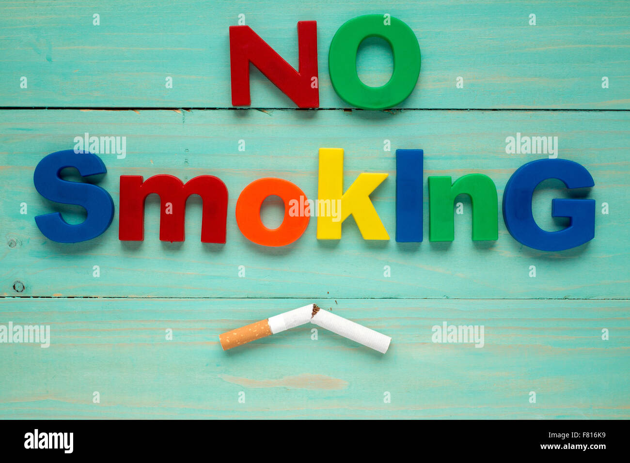 how do you spell cigarettes Broken cigarette and plastic letters spelling no smoking Stock Photo