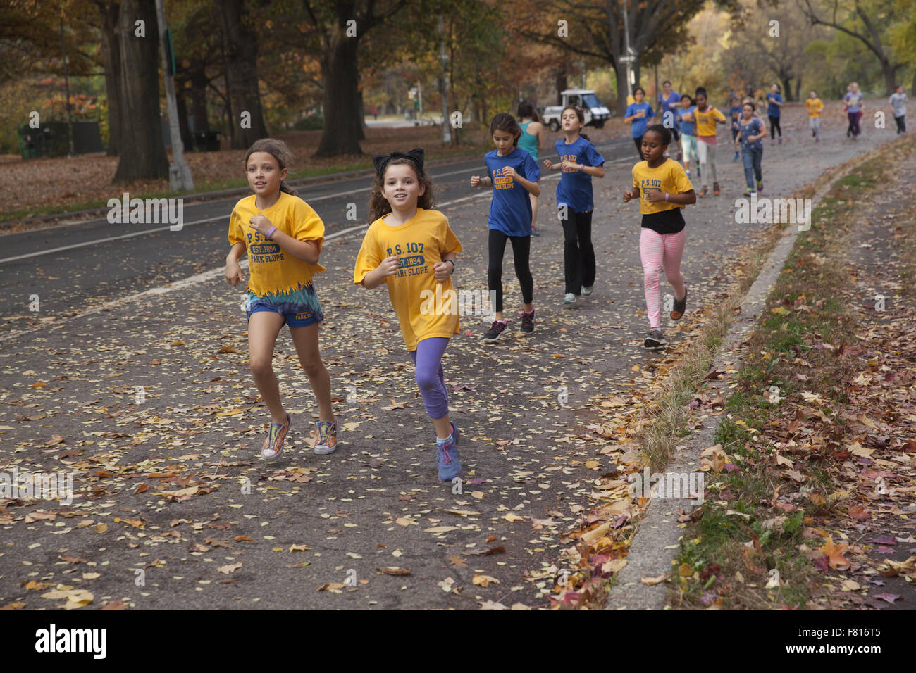 Local elementary school children jogging together on the road in Prospect Park, Brooklyn, New York. Stock Photo