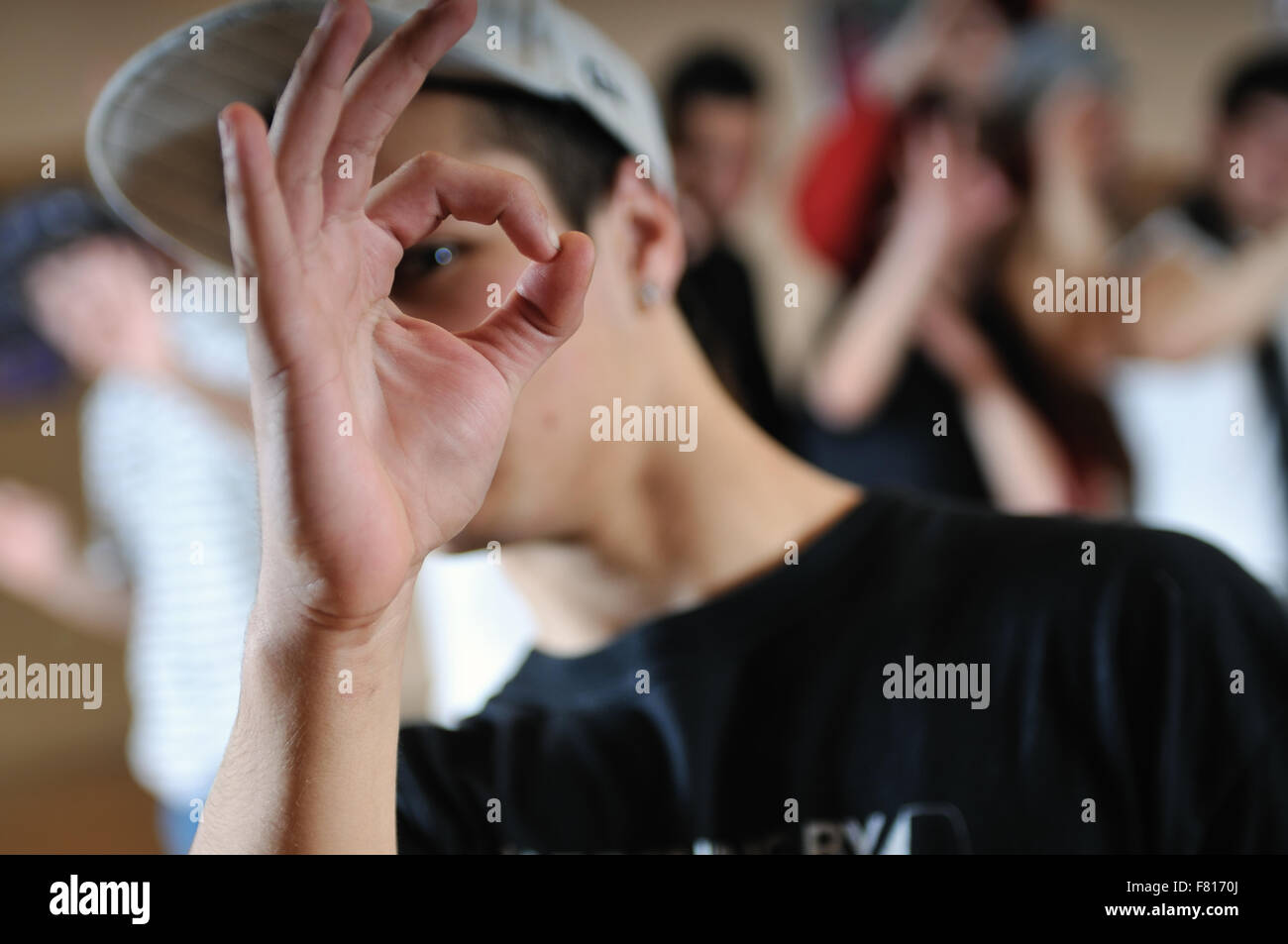 young boy with group in bacground showing ok sign Stock Photo - Alamy