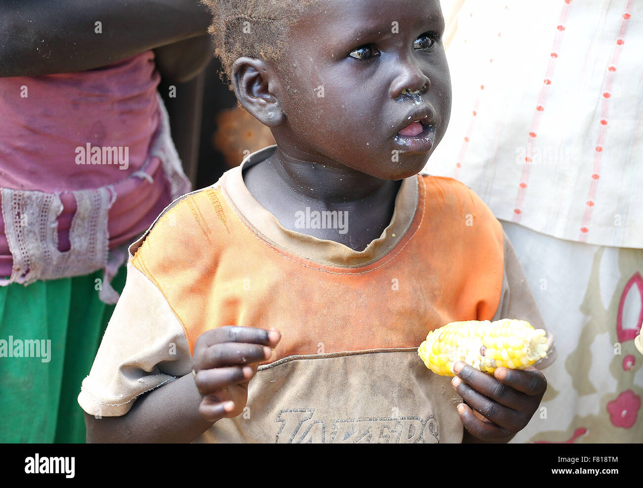 A young girl eats corn an Internally Displaced Persons camp in Turalei, Warrap State of South Sudan Sept 19, 2015. World Vision has been been working in this hard to reach region since 1989 providing humanitarian relief and development assistance. 16th Sep, 2015. Photo Andre Forget © ©/ZUMA Wire/Alamy Live News Stock Photo
