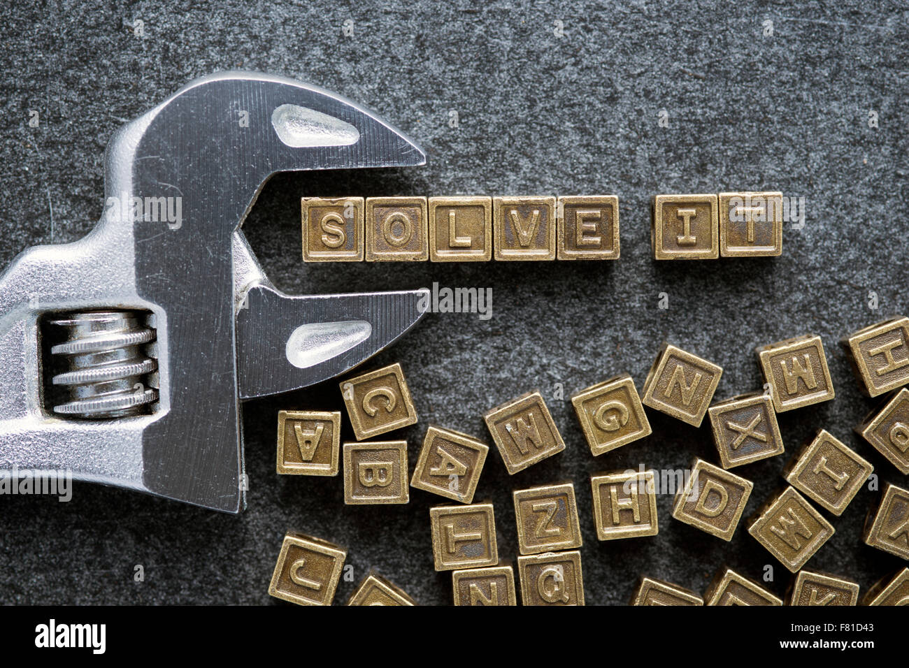 solve it slogan made from metallic toy blocks with adjustable wrench on blackboard surface Stock Photo