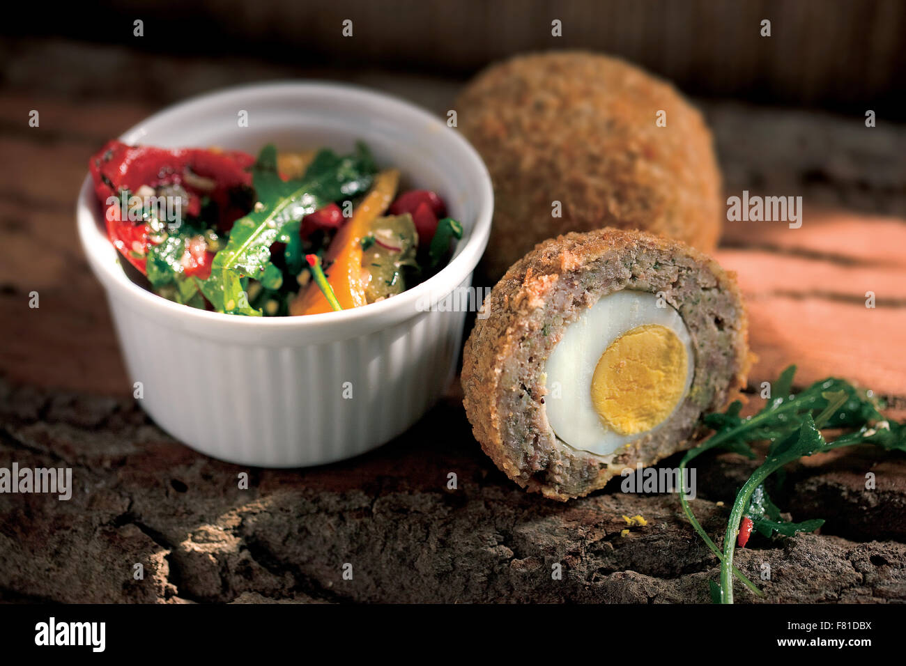 Scotch egg and ramekin with salad leaves Stock Photo
