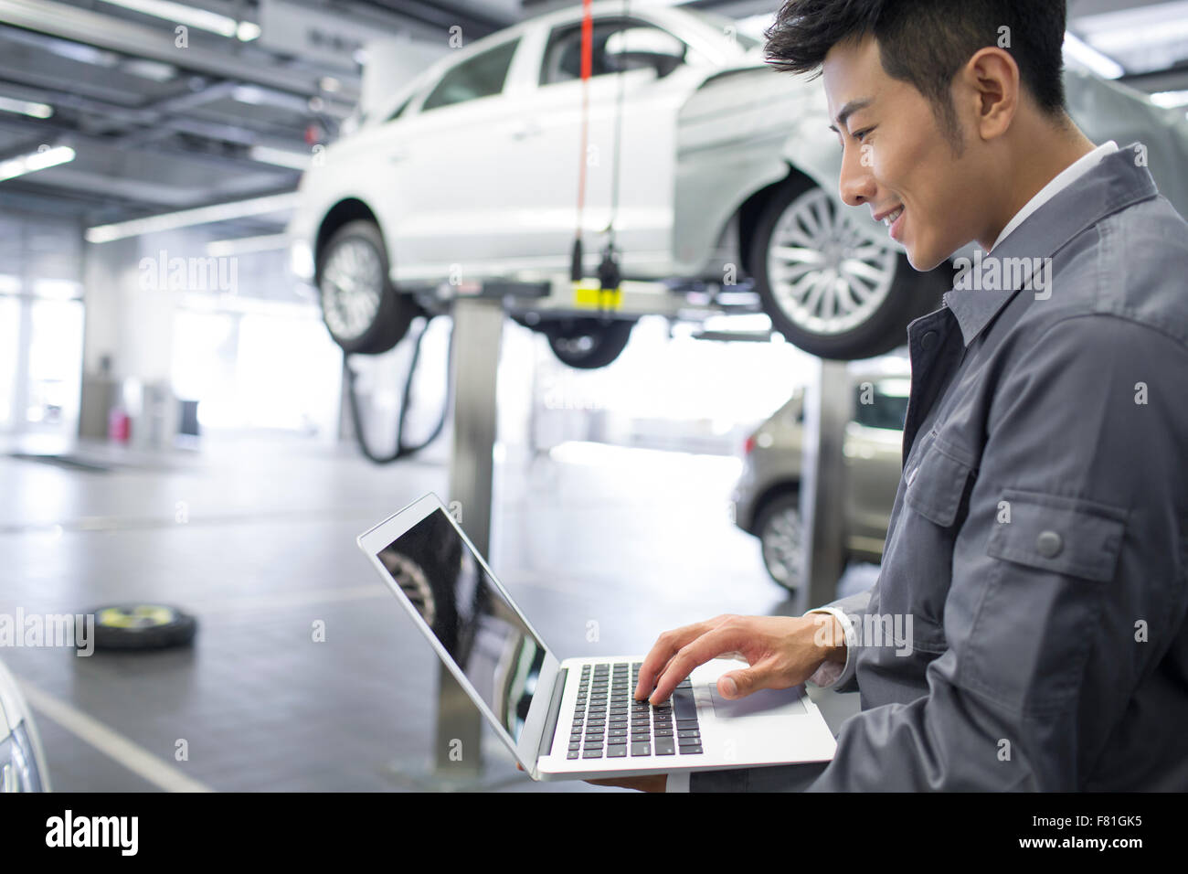 Auto mechanic using laptop Stock Photo - Alamy