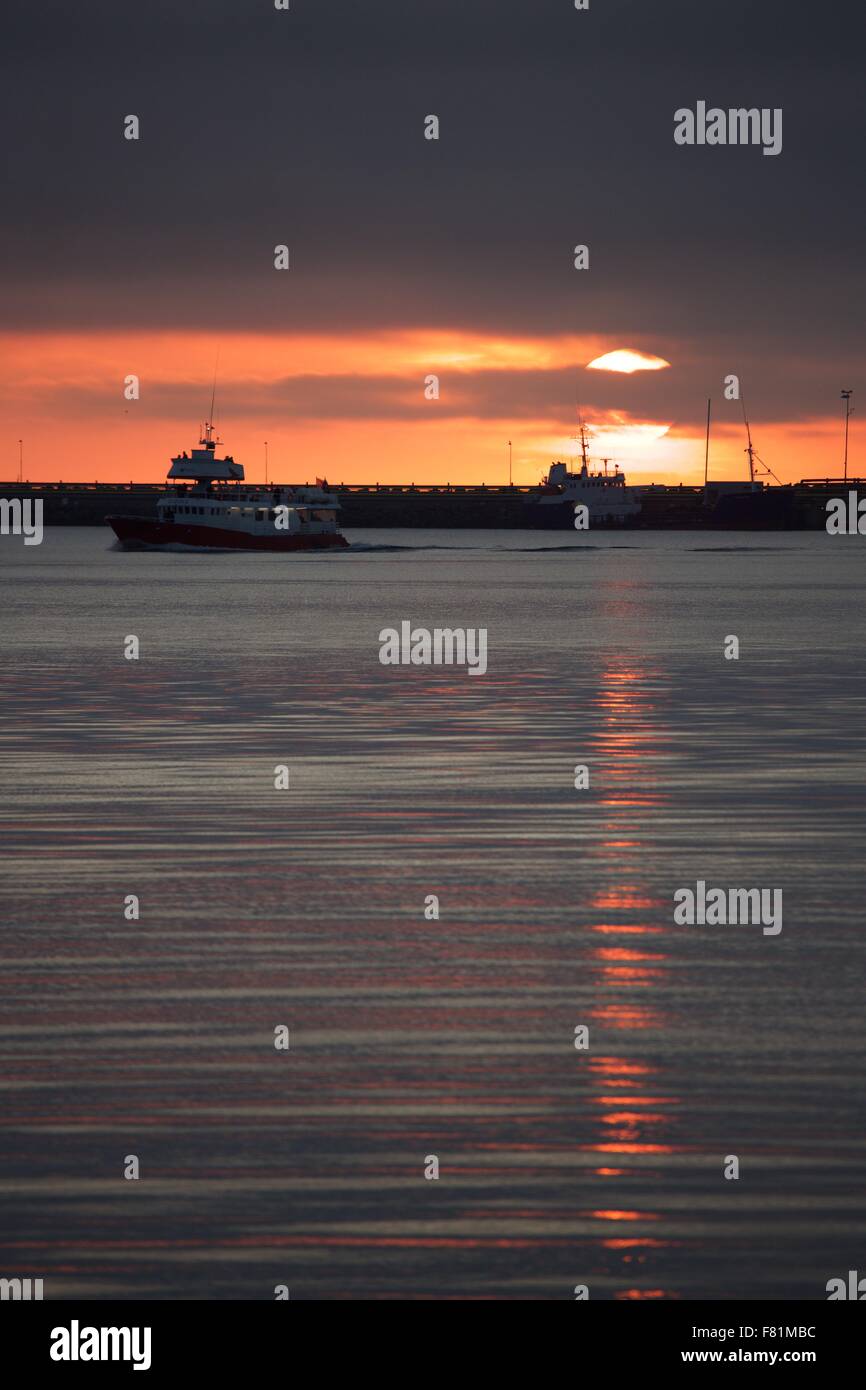 The midnight summer sun sets on the Summer Solstice over the harbor in Reykjavik, Iceland Stock Photo