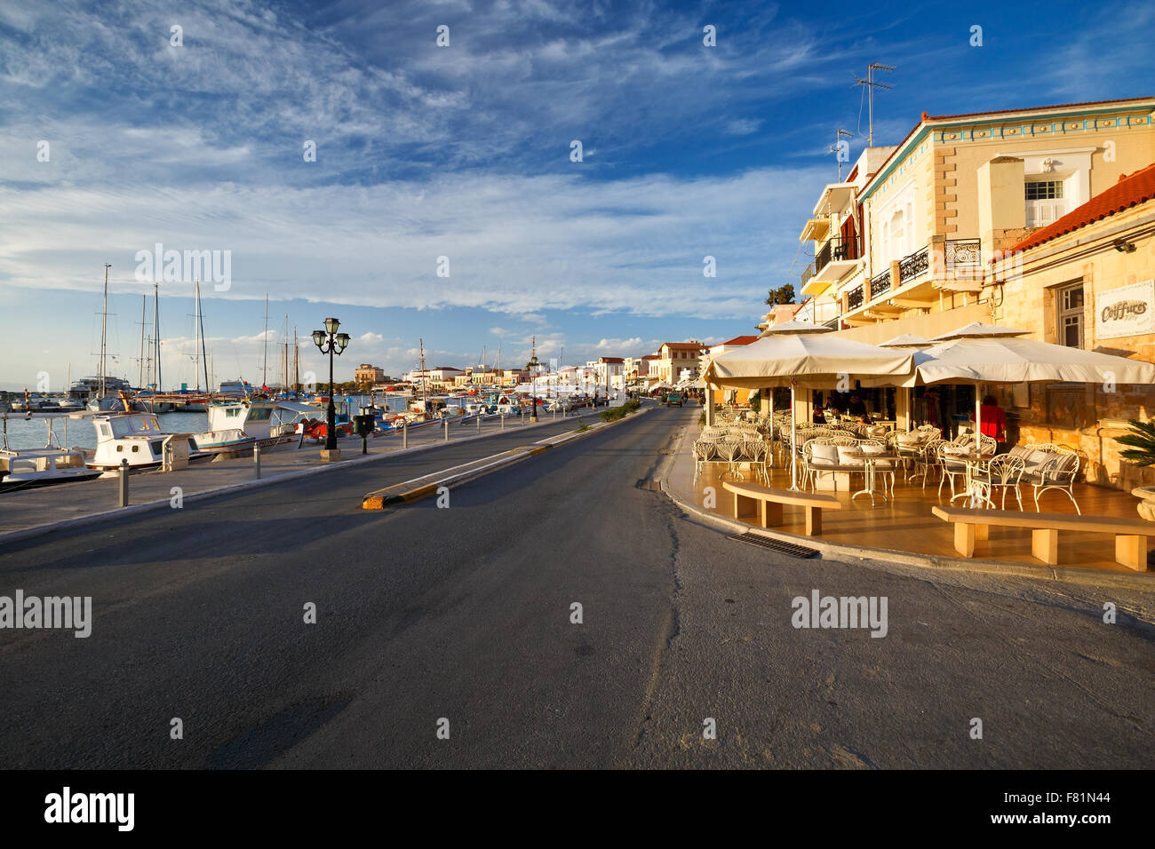 Street view of the coffee shops, bars and restaurants and the harbour of Aegina town, Greece Stock Photo