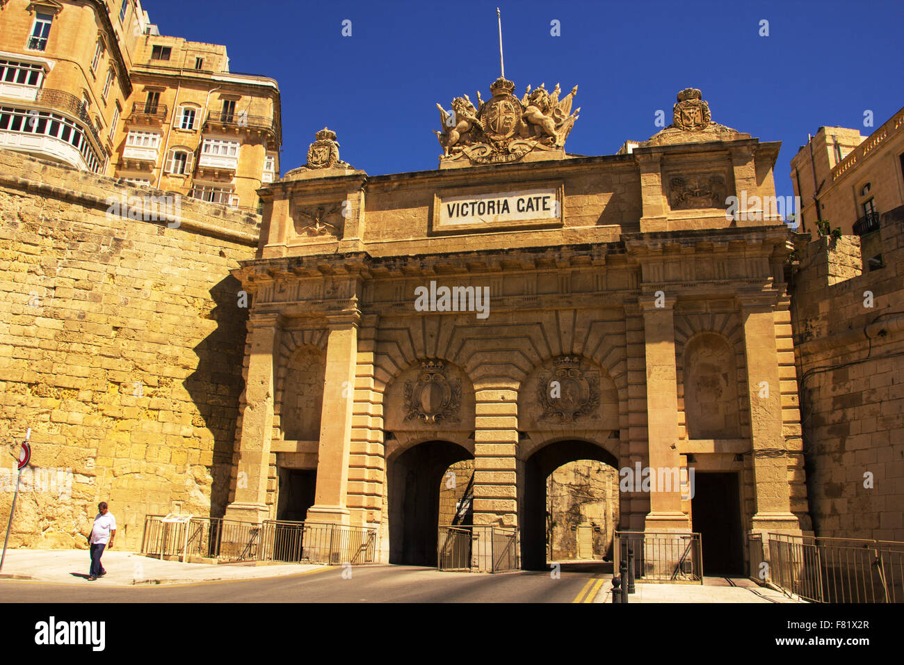 Man walking away from Victoria cate archway in Valletta Stock Photo