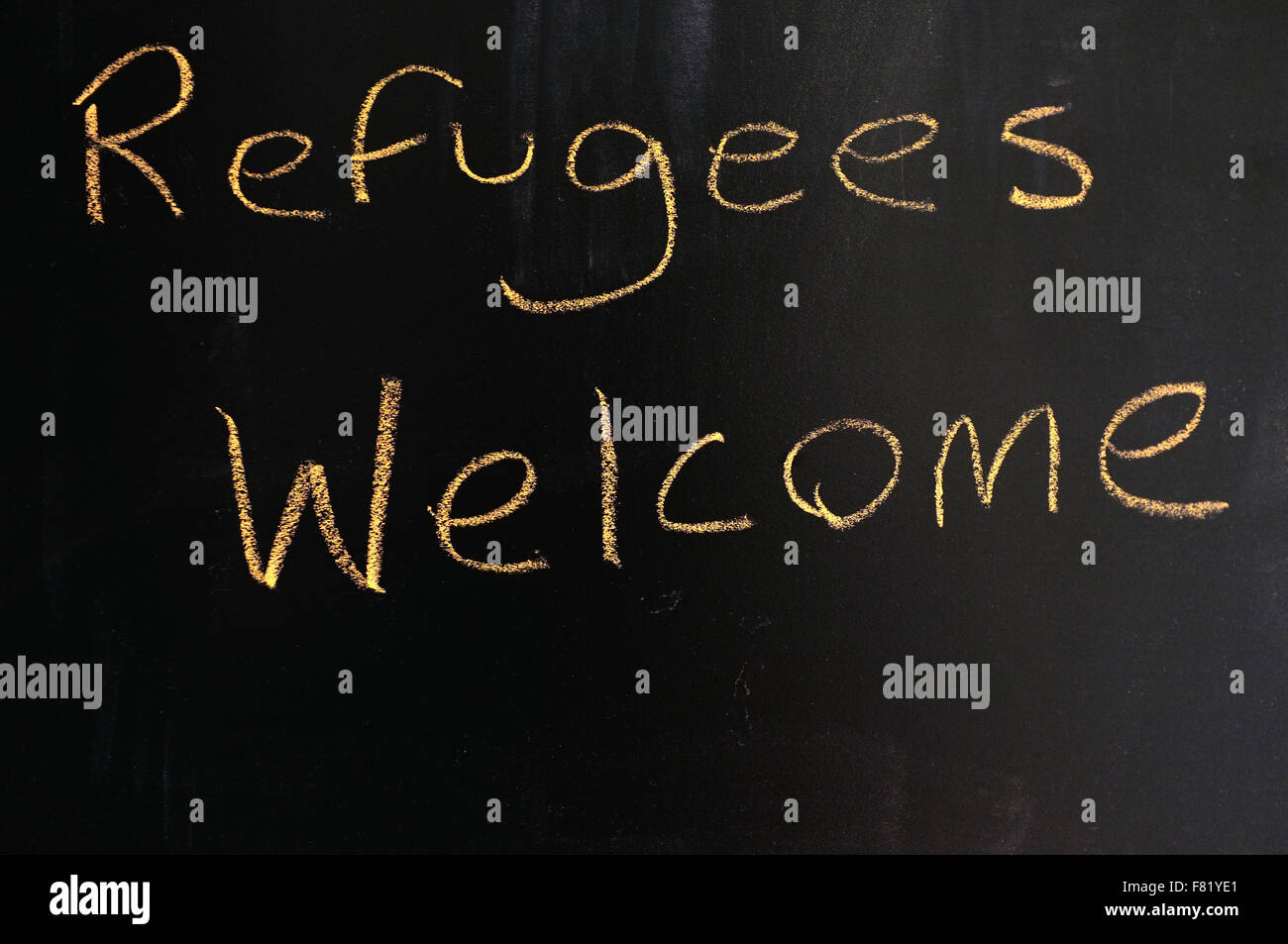 Refugees Welcome written on a blackboard in chalk. Stock Photo