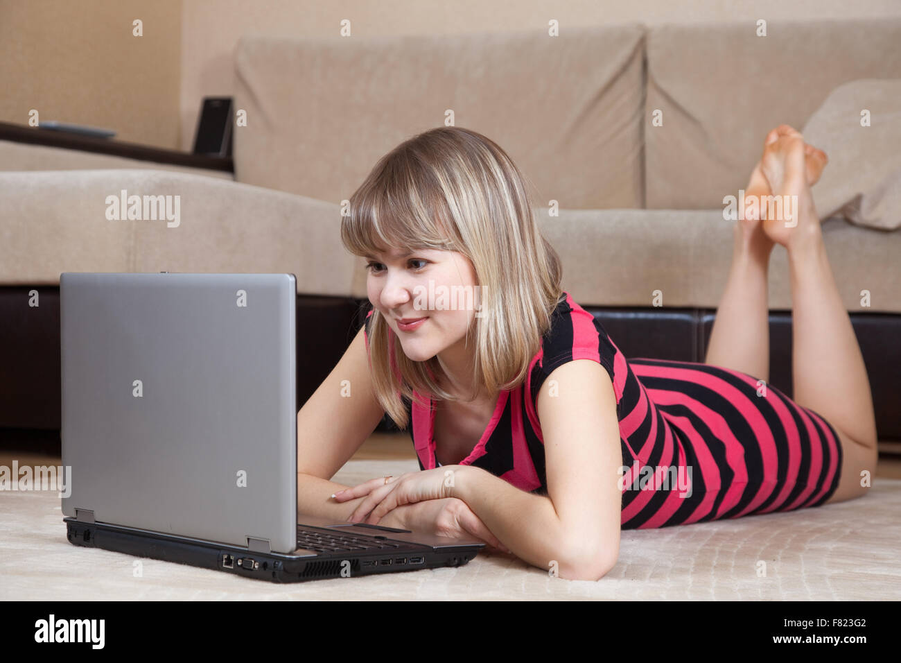 young girl lying on floor and using laptop Stock Photo - Alamy