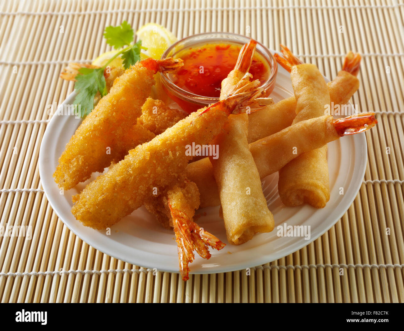 Close up of Oriental Chinese breaded and battered deep fried tiger prawns with a sweet chilli dip ready to eat Stock Photo