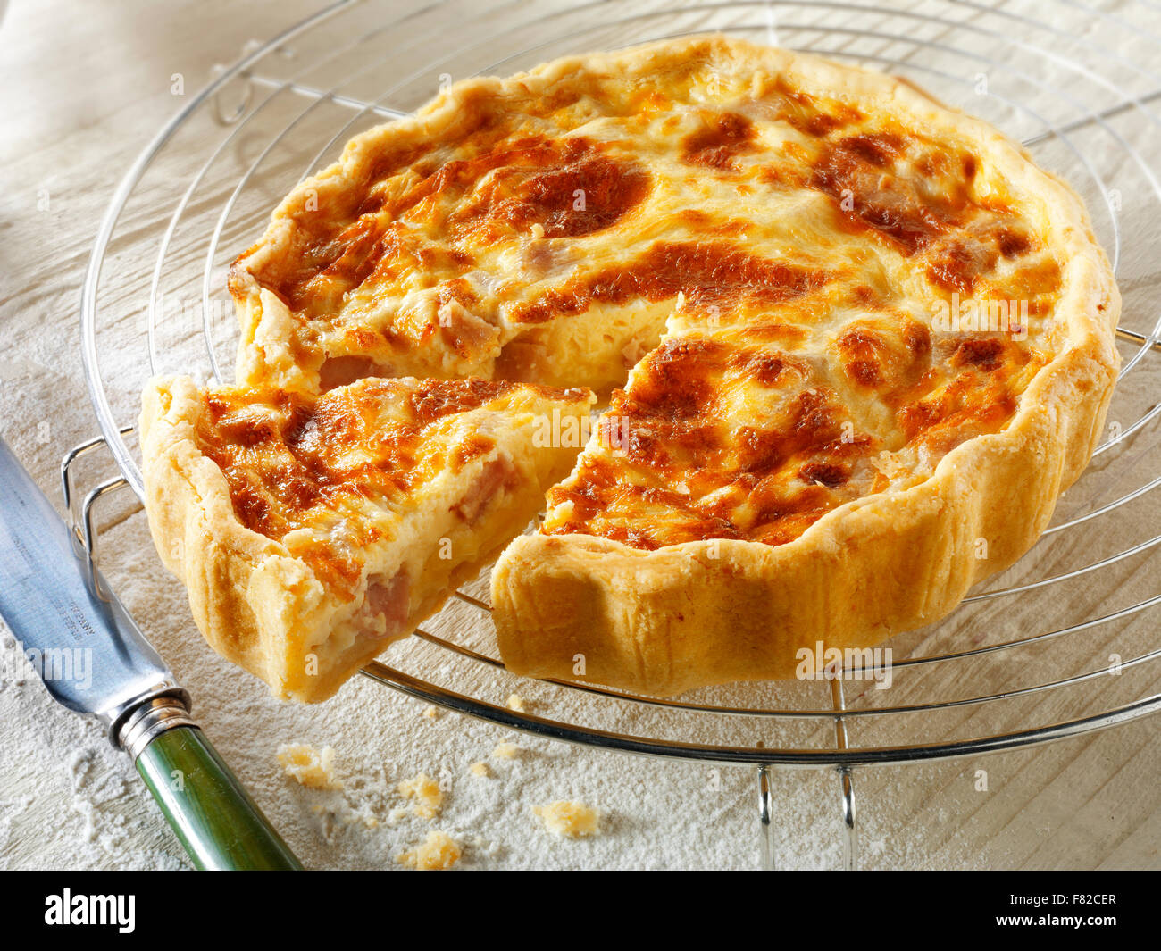 Cooked traditional French Quiche Lorraine with a cut slice Stock Photo