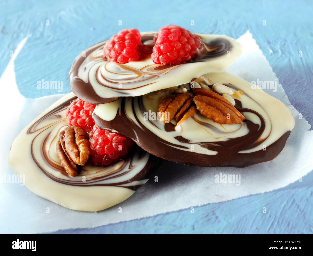 Melted milk and white chocolate swirls recipe with fruit and nuts Stock Photo