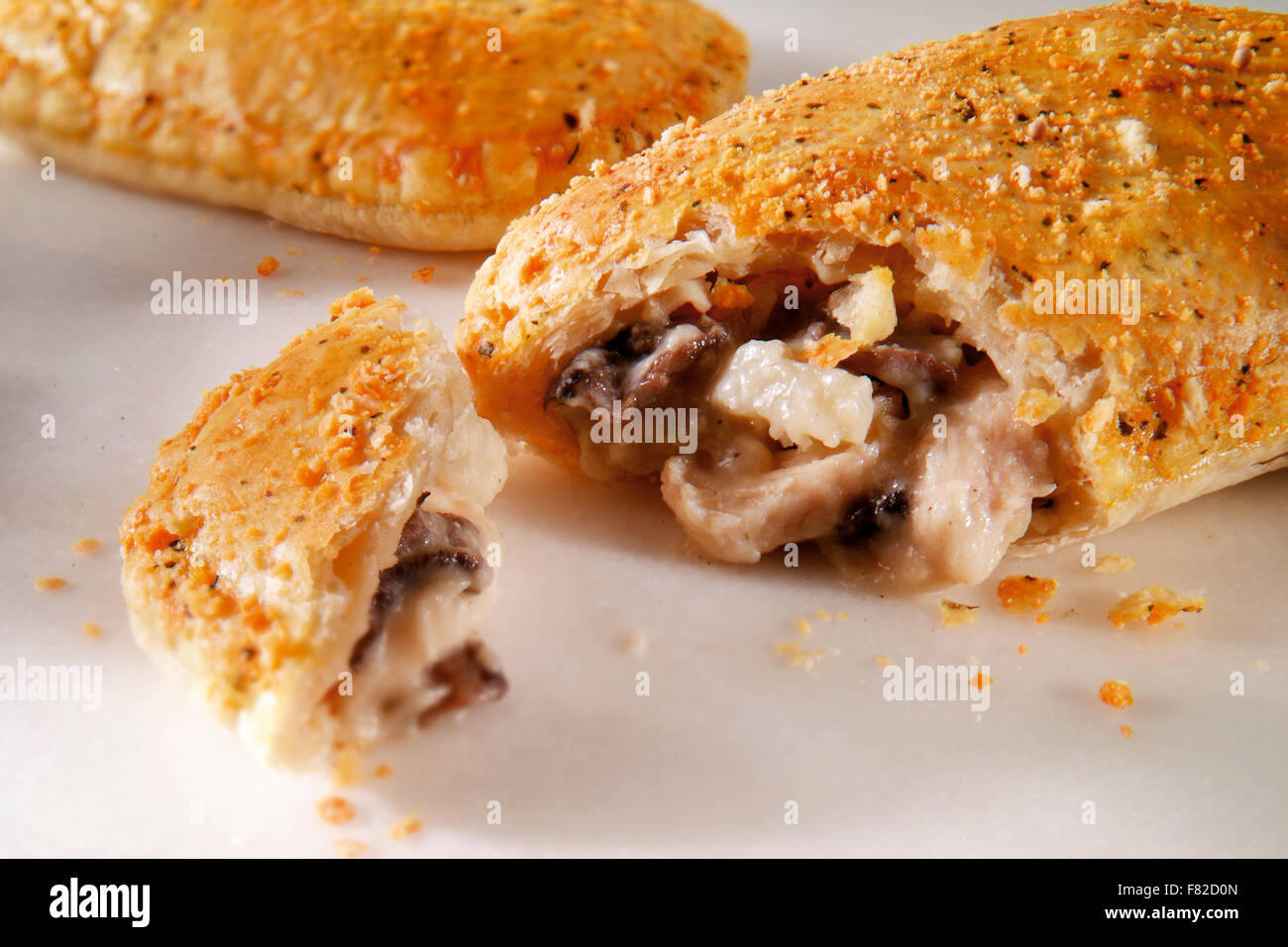 Cooked chicken & mushroom puff pastry slice cut open against a white background Stock Photo