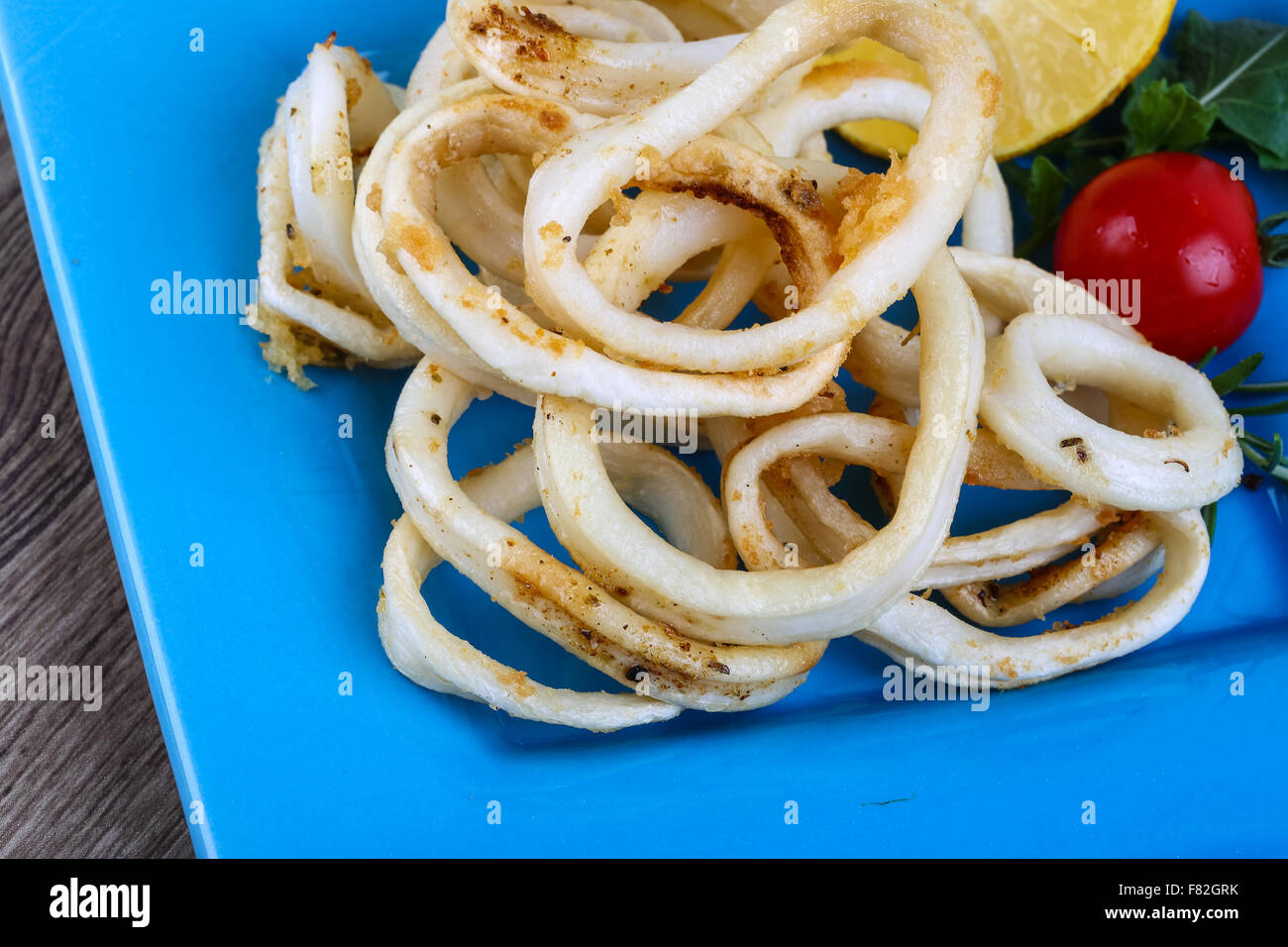 Fried squid rings with lemon, herbs and spices Stock Photo Alamy