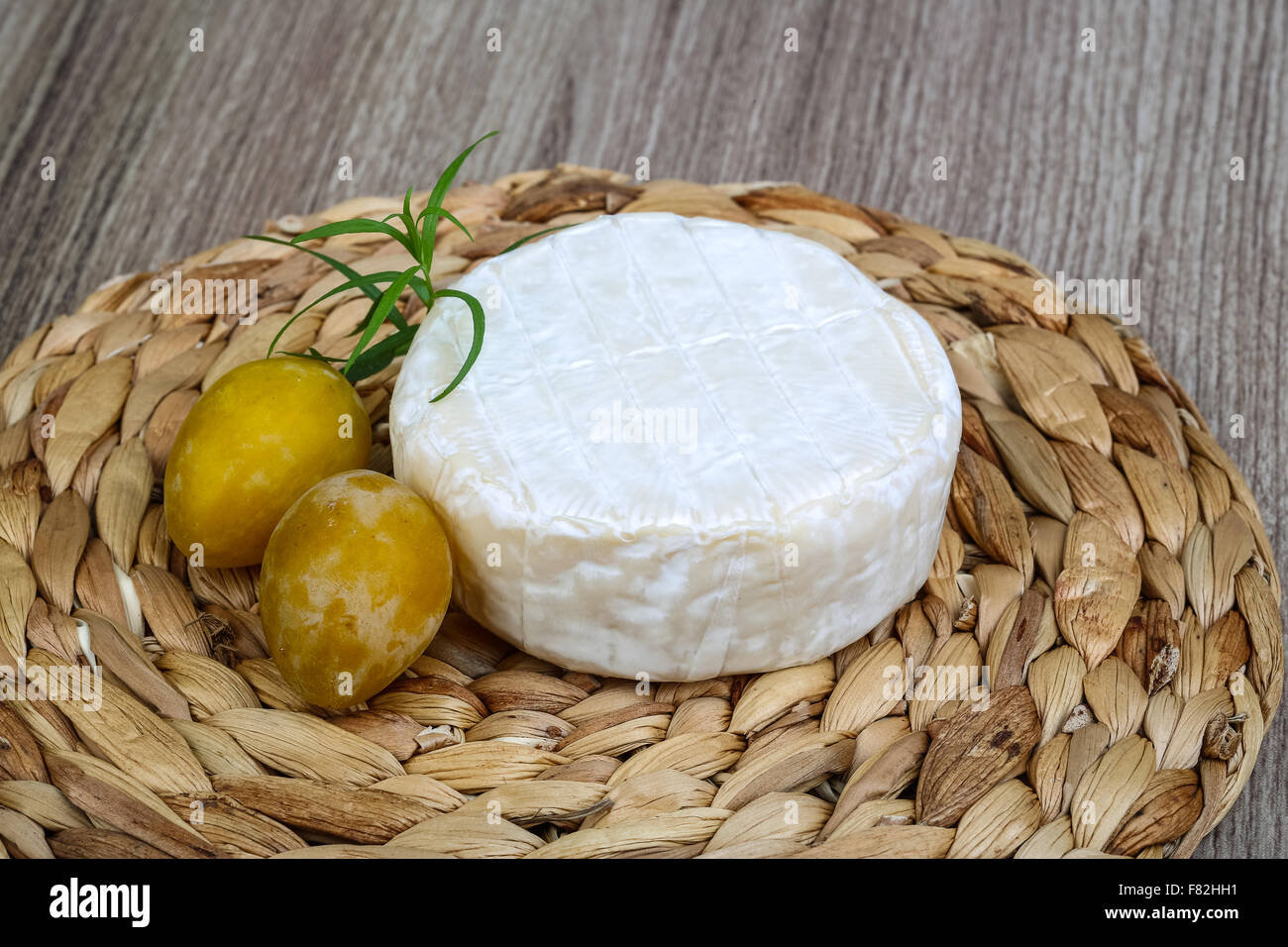 Brie cheese with yellow plums and estragon leaves Stock Photo Alamy