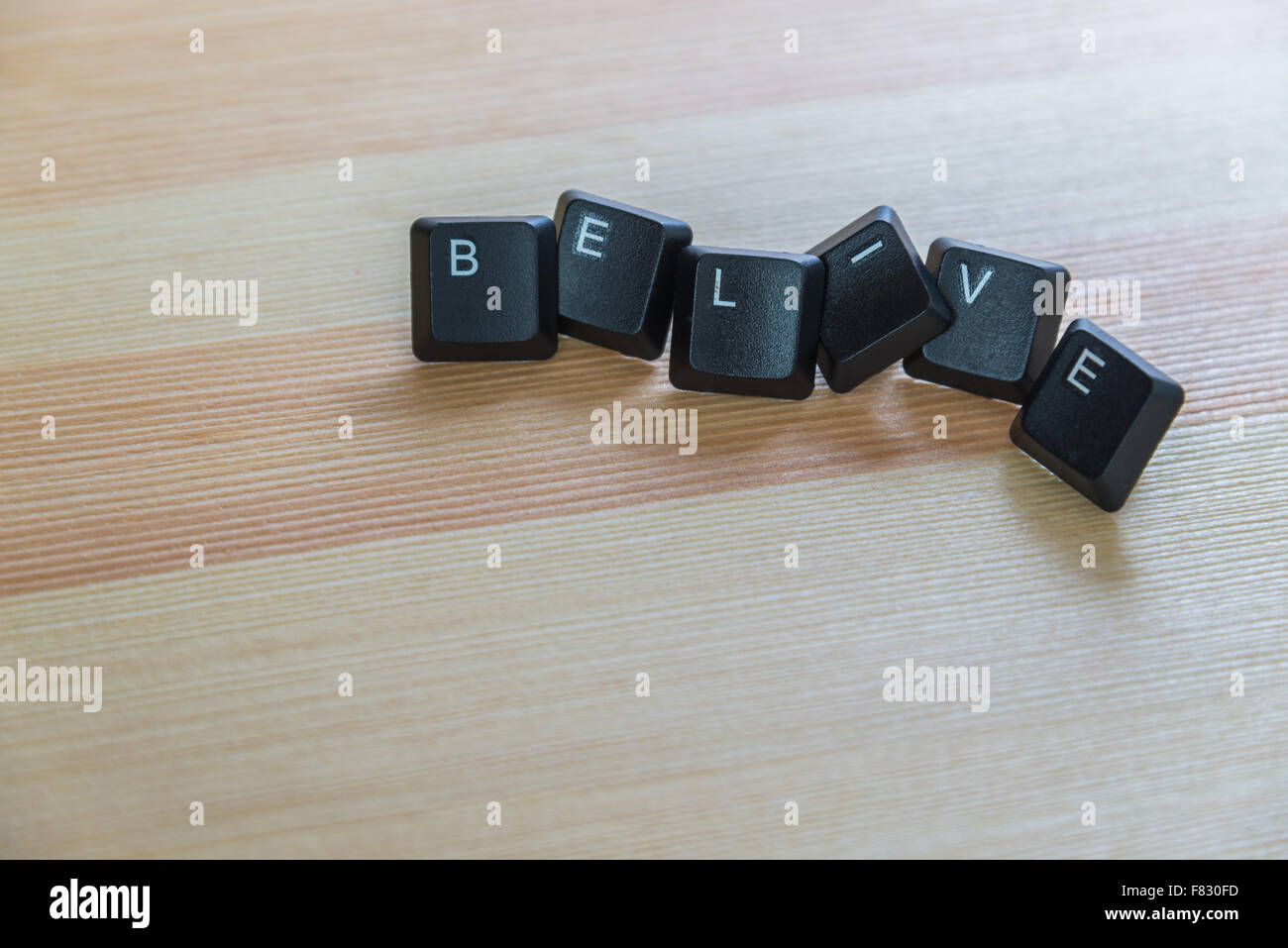 Belive word keyboard on wooden floor Stock Photo