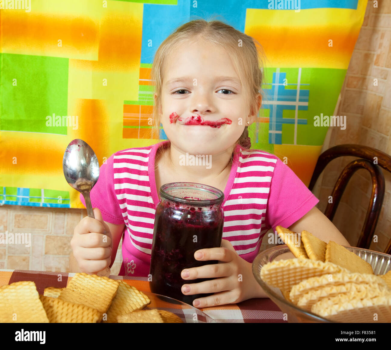 Little girl eating jam from jar at kitchen Stock Photo Alamy