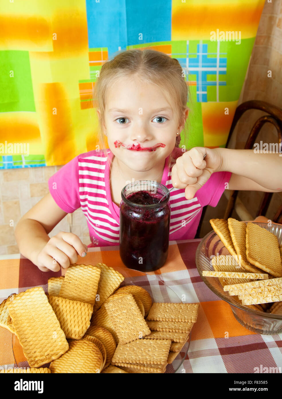 Little girl eating jam from jar at kitchen Stock Photo Alamy