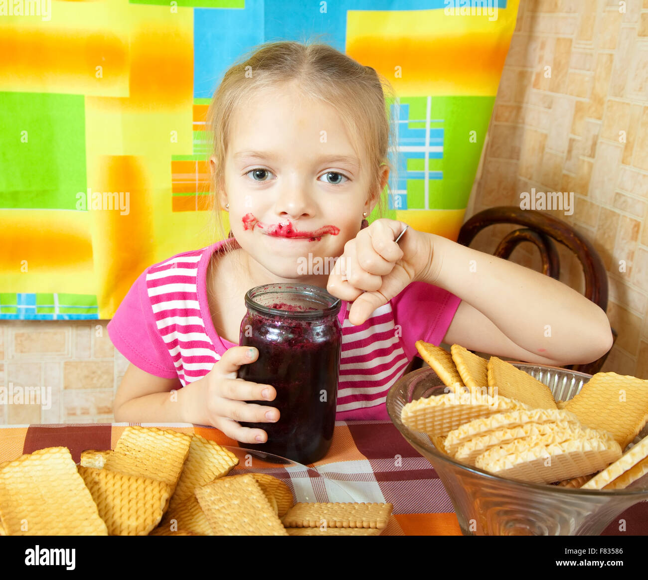 Little girl eating jam from jar at kitchen Stock Photo Alamy