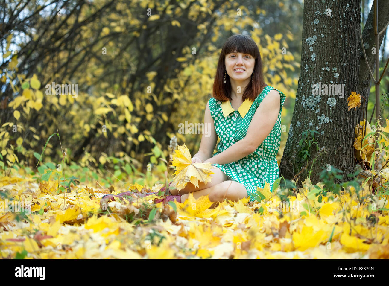 Girl in green dress at autumn park Stock Photo - Alamy