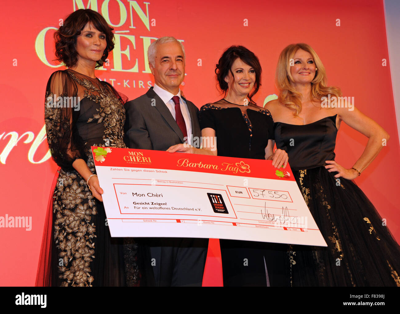 The host of the evening and CEO of chocolate manufacturer Ferrero, Carlo Vassallo (2nd L), actress Iris Berben (2nd R), presenter Frauke Ludowig (R) and model Helena Christensen (l) present the charity donation during the Barbara Day celebrations hosted by chocolate manufacturer Mon Cheri in Munich, Germany, 4 December 2015. The charity event to place in aid of the organisation 'Gesicht zeigen! Fuer ein weltoffenes Deutschland e.V.', which is an association committed to raising awareness against discrimination and to strengthening social civility. Photo: Ursula Dueren/dpa Stock Photo