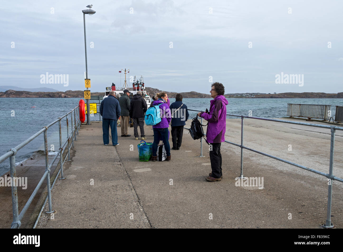 Passengers waiting for the Calmac ferry the 'Loch Buidhe', on the Isle of Iona, Inner Hebrides, Scotland, UK Stock Photo