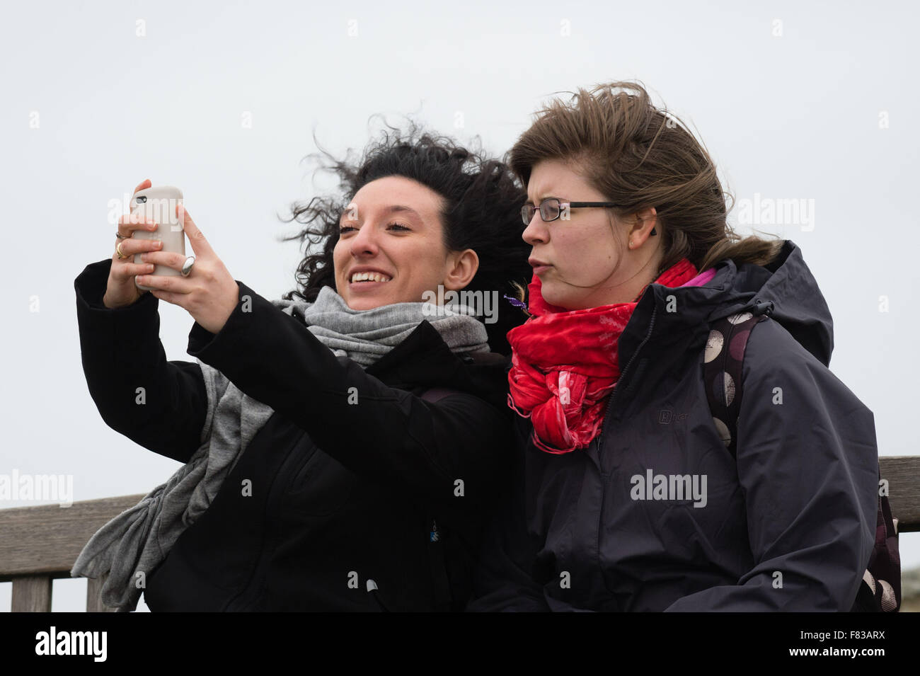 Aberystwyth Wales UK, Saturday 05 December 2015  Two women take a 'selfie' as they get blown by high winds  The fourth named storm of the season, Storm Desmond, picks up strength and begins to batter the coast at Aberystwyth, west Wales  photo: © Keith Morris / Alamy Live  News Stock Photo