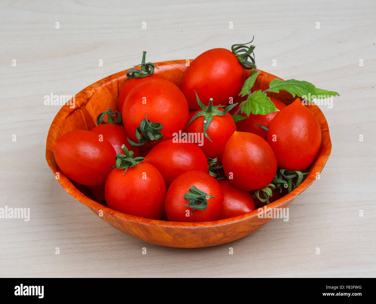 Cherry tomatoes in the basket with fresh green leaf Stock Photo - Alamy
