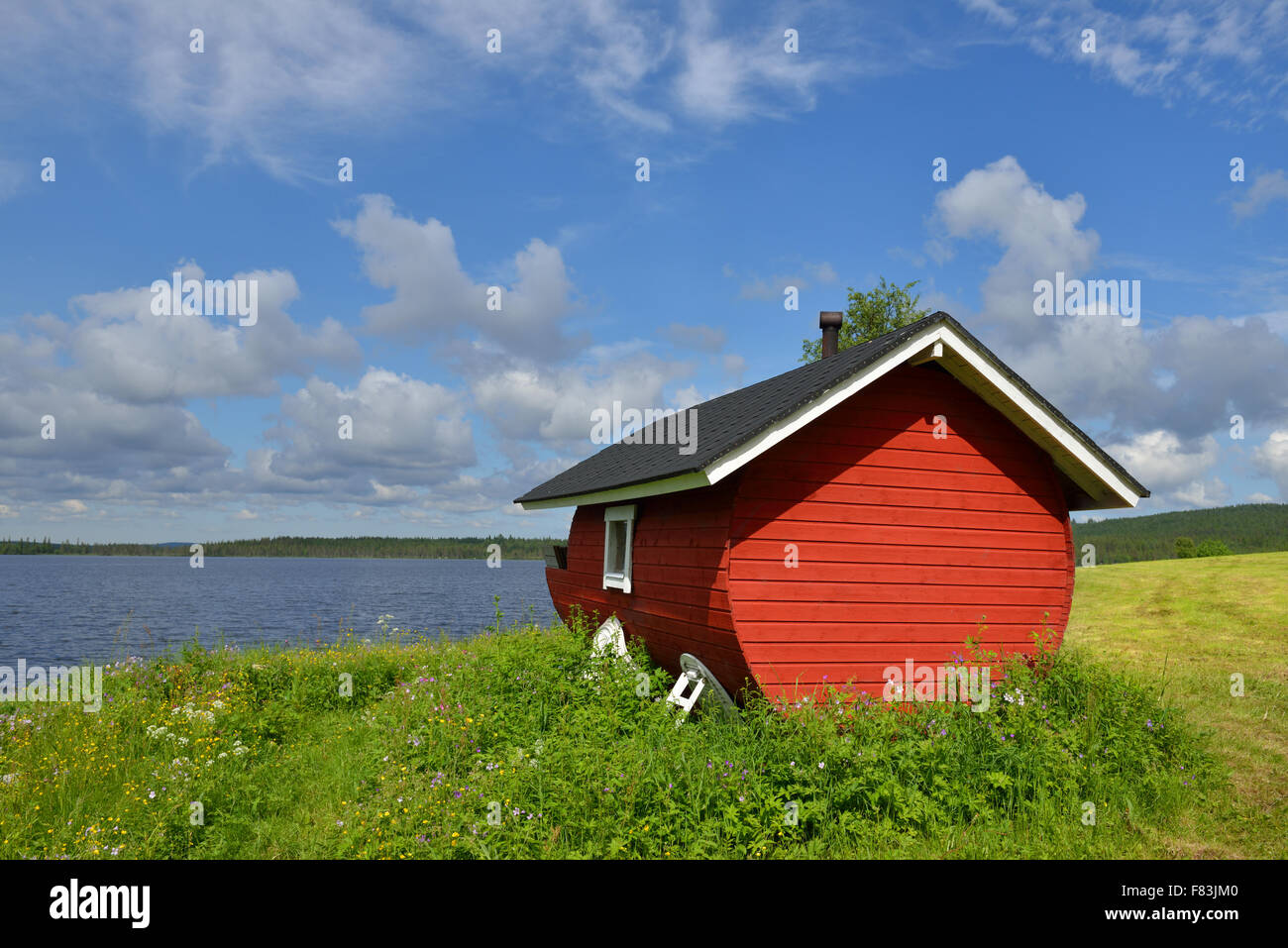 Finnish sauna on the shore of the blue lake summer day. Northern
