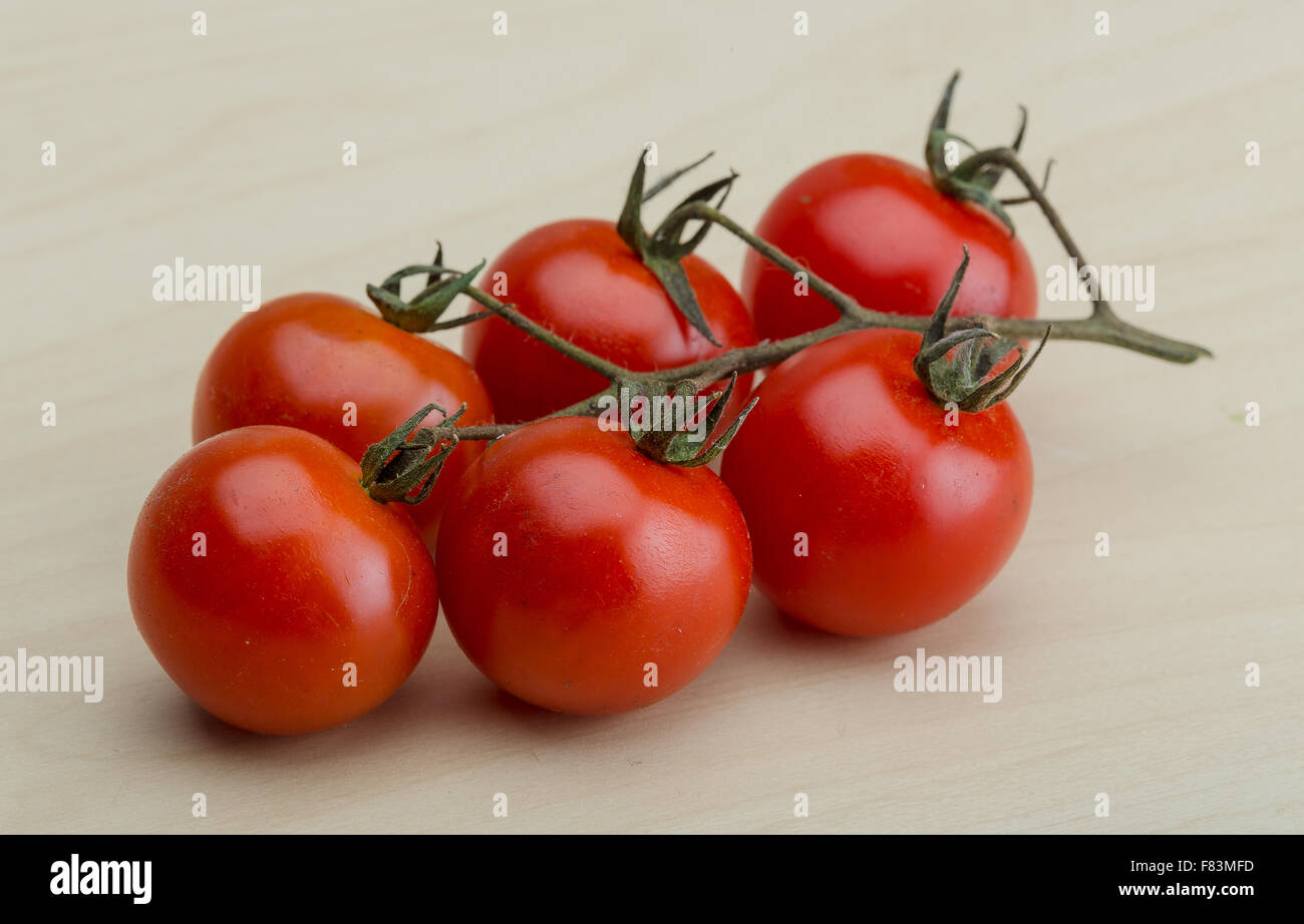 Cherry tomatoes branch on the wood background Stock Photo - Alamy