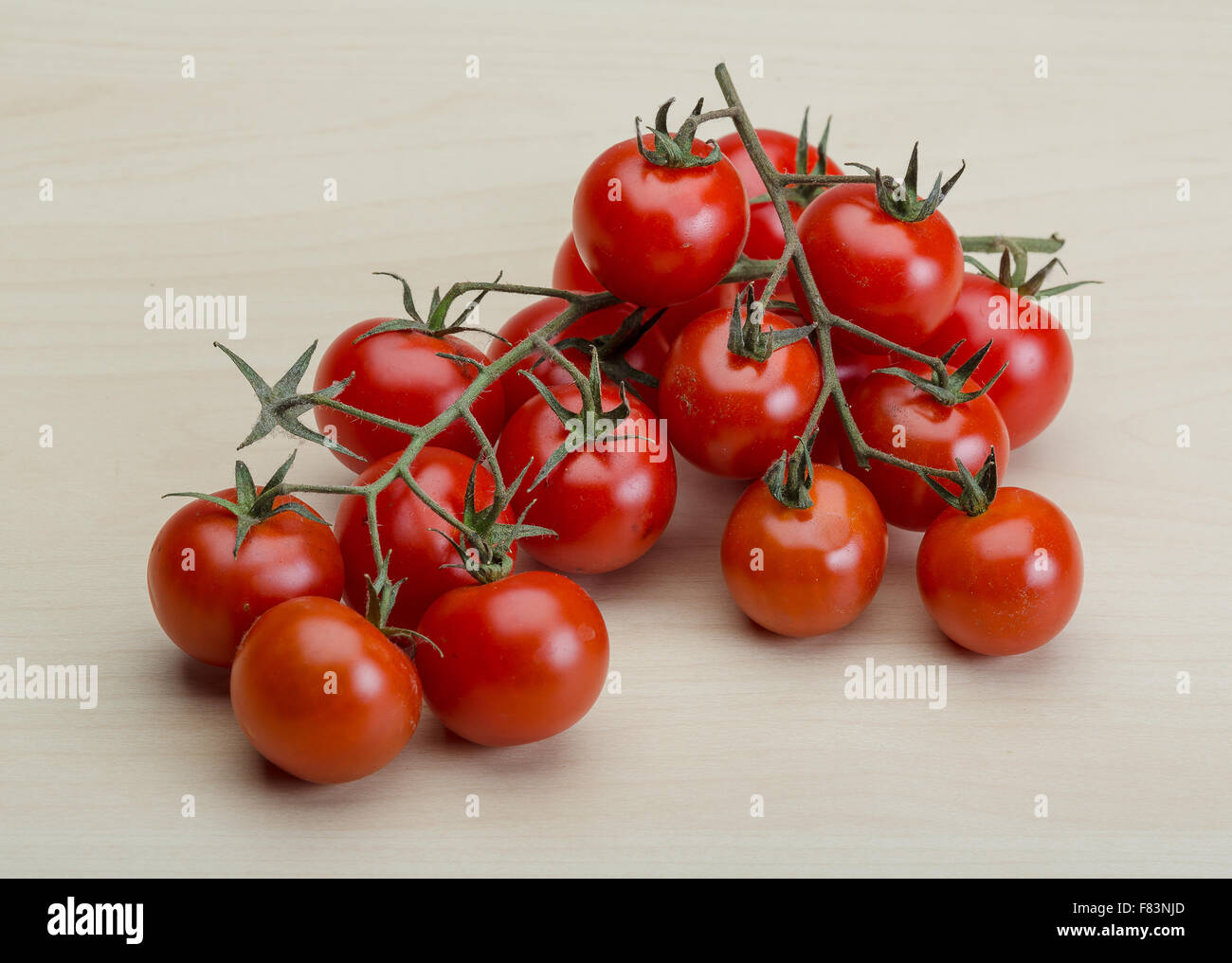 Cherry tomatoes branch on the wood background Stock Photo - Alamy