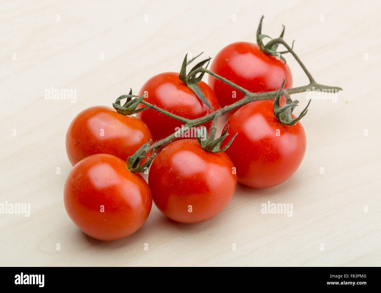 Cherry tomatoes branch on the wood background Stock Photo - Alamy