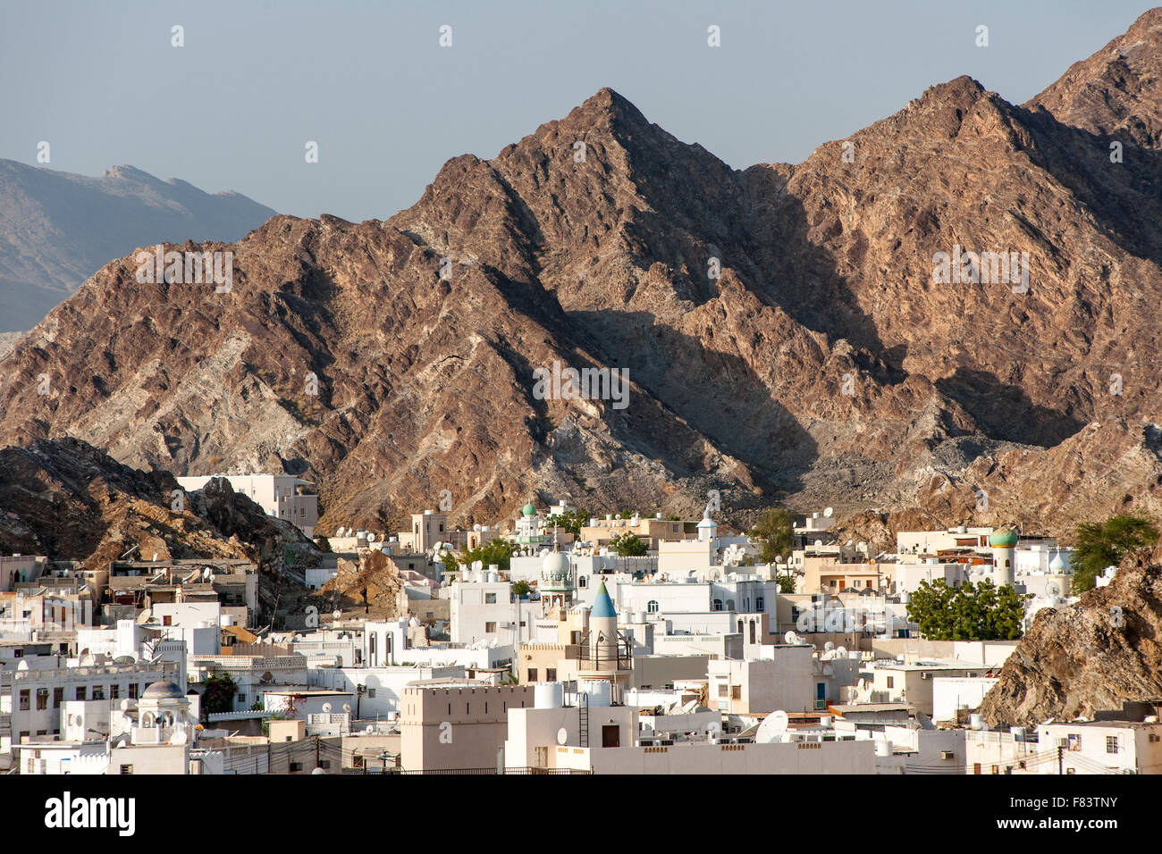 Houses and surrounding mountains in the district of Mutrah in Muscat, the capital of the Sultanate of Oman. Stock Photo