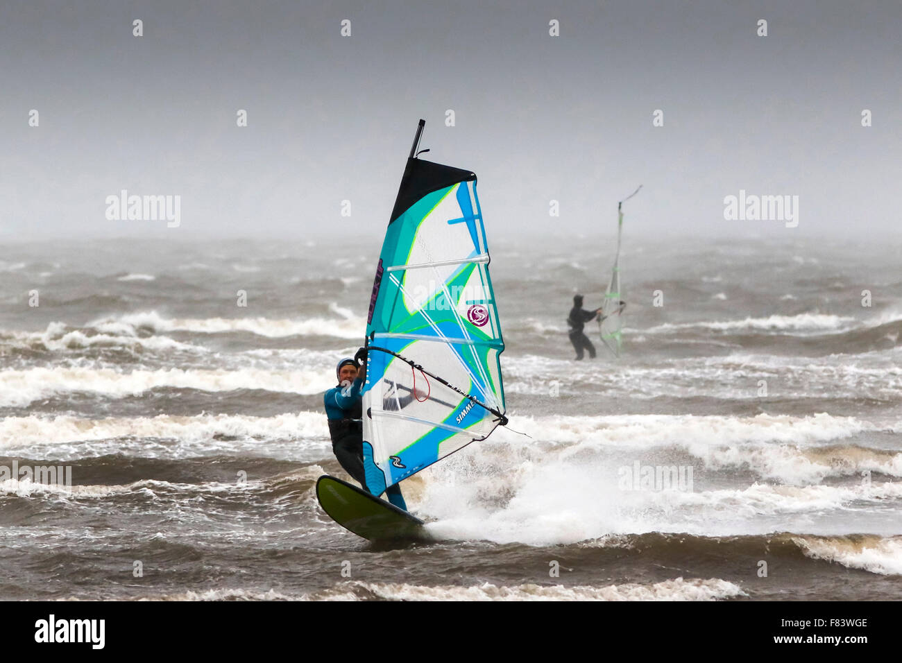 Troon, Ayrshire, UK. 05th Dec, 2015. As storm Desmond hammers the Ayrshire coast with high winds and heavy rain, not everyone is complaining about the weather.These windsurfers, off the beach at Troon, Ayrshire, are taking advantage of the weather conditions and high waves to enjoy their sport. Credit:  Findlay/Alamy Live News Stock Photo