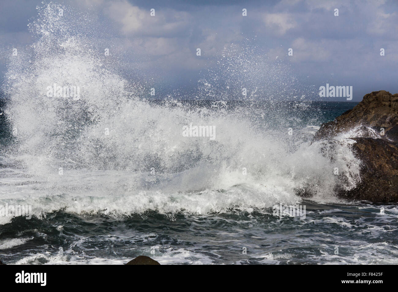 big wave splashing on rock -  waves breaking on shore Stock Photo