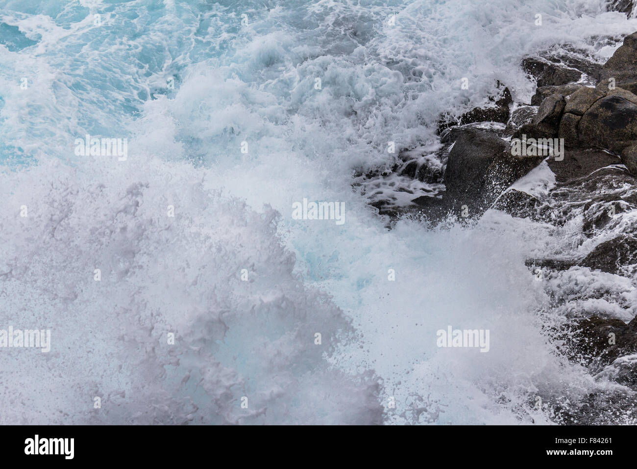 waves breaking on shore - waves splashing on rocks Stock Photo