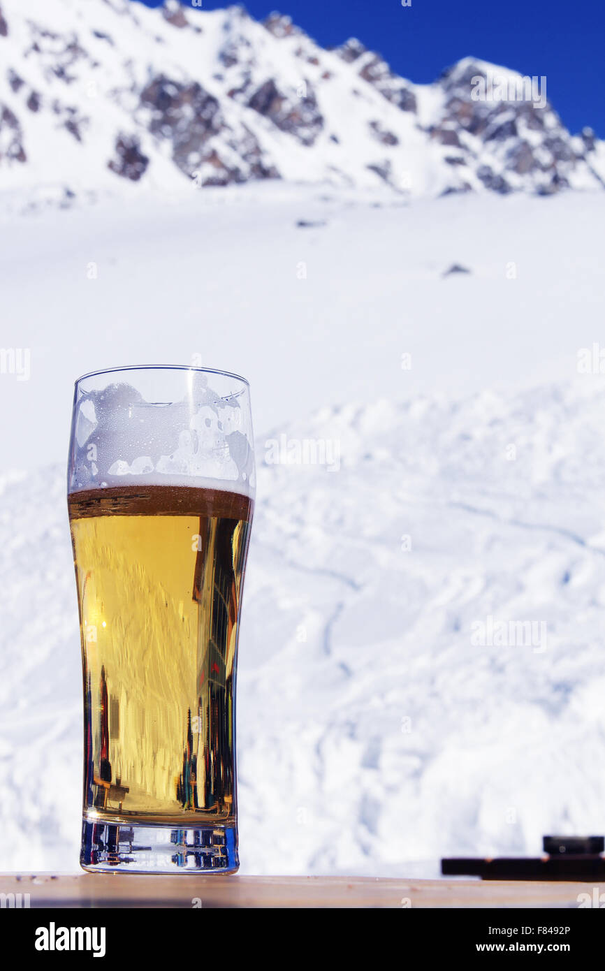 Glass with beer on a wooden table in high mountain cafe Stock Photo