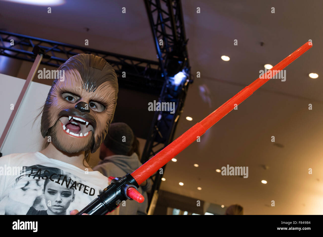 Zurich, Switzerland. 05th Dec, 2015. A little girl is posing with a  lightsaber and the mask of Star Wars character Chewbacca during a Star Wars  movie promotion event in a Zurich shopping