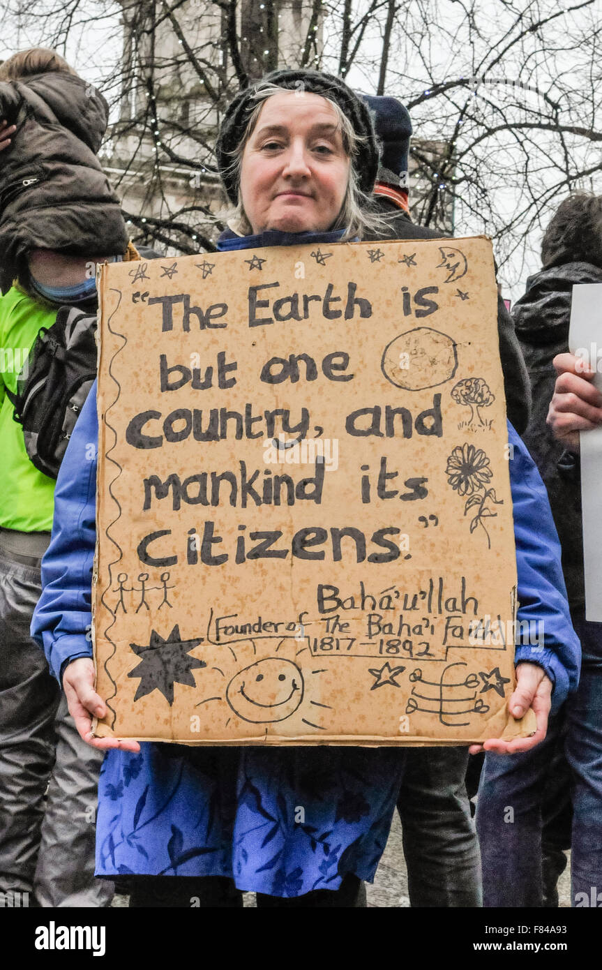 Belfast, Northern Ireland. 05 Dec 2015 - Pro-refugee supporter holds a banner which says 'The Earth is but one country, and mankind its citizens' as she attends a gathering to protest against the Protestant Coalition's anti-refugee rally. Credit:  Stephen Barnes/Alamy Live News. Stock Photo