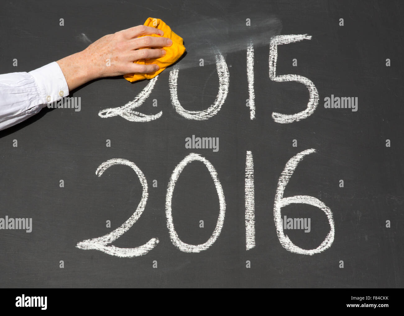 The new year is coming, with the date 2015 and 2016 written on a school blackboard, with the year 2015 being erased by a teacher Stock Photo