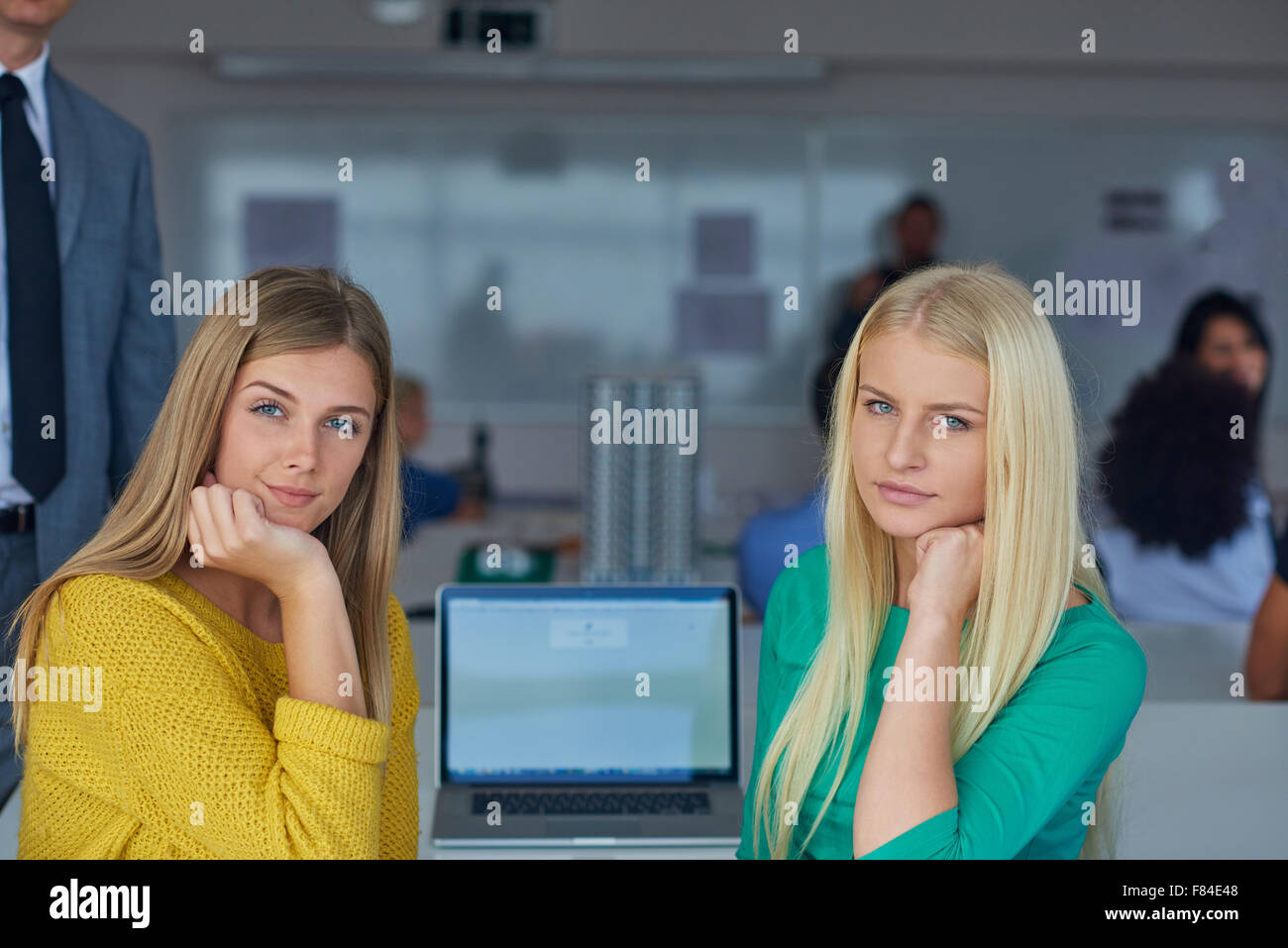 portrait of happy student girls together in classroom, laptop computer ...