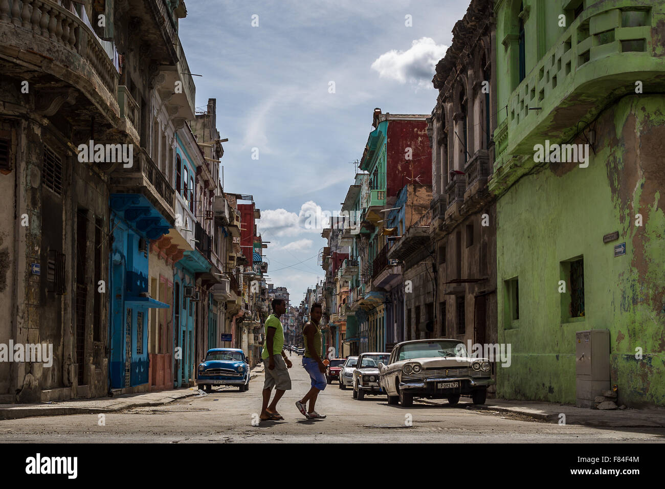 Two men in their twenty's cross the road at a junction in Centro Havana. Stock Photo
