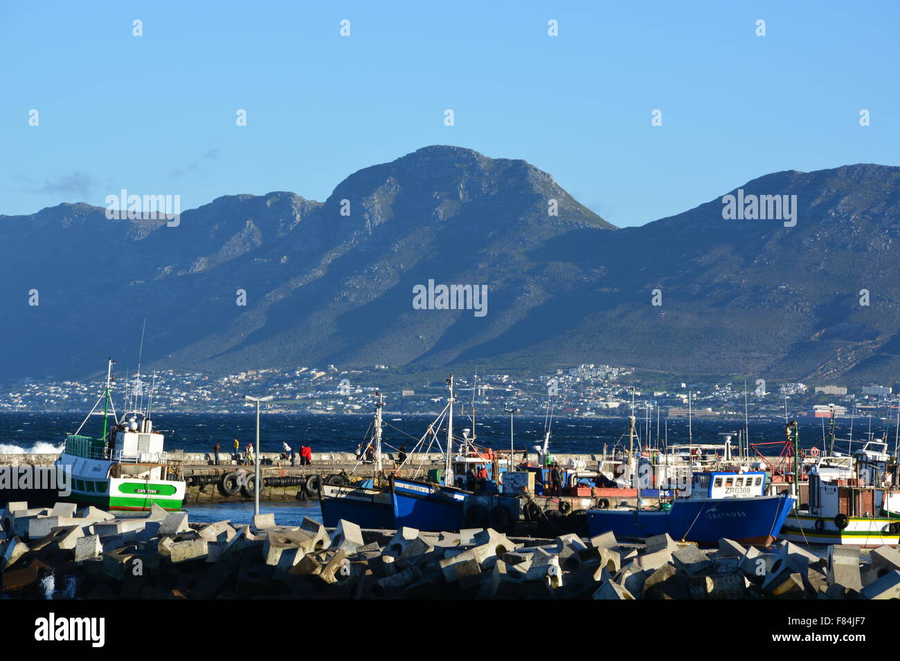 Fishing boats in harbor behind the sea wall at Kalk Bay, South Africa Stock Photo