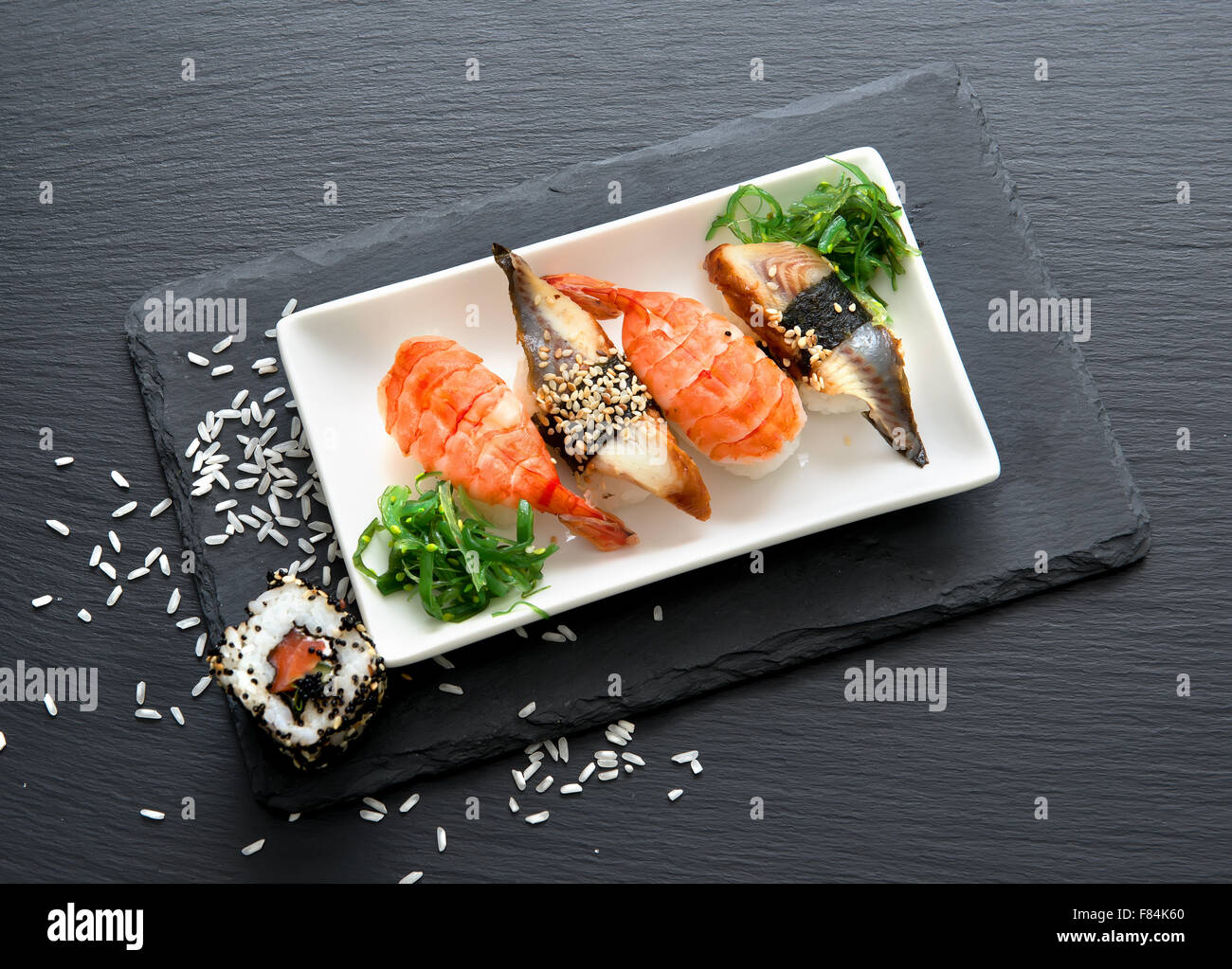 Sushi with salad in plate on a black slate table Stock Photo